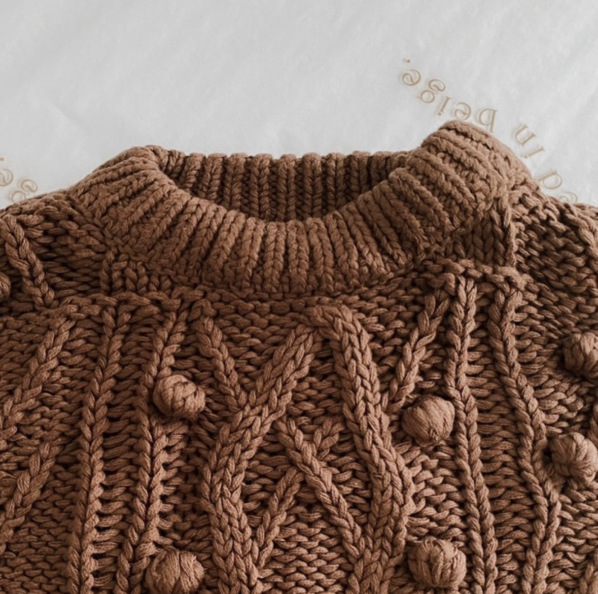 Close up flatlay on neckline and knit bobbles of chocolate bobbie jumper