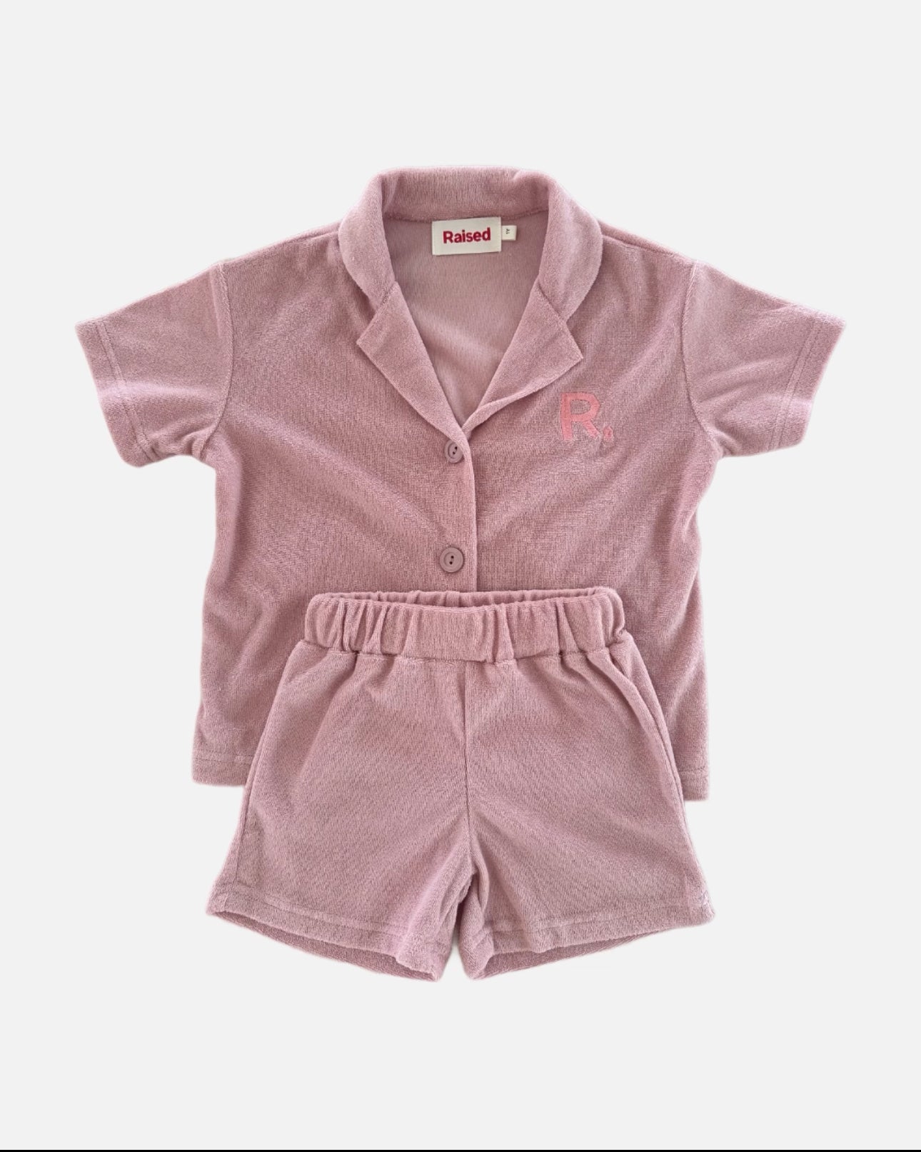 Flat lay of watermelon terry set, button up shirt and shorts