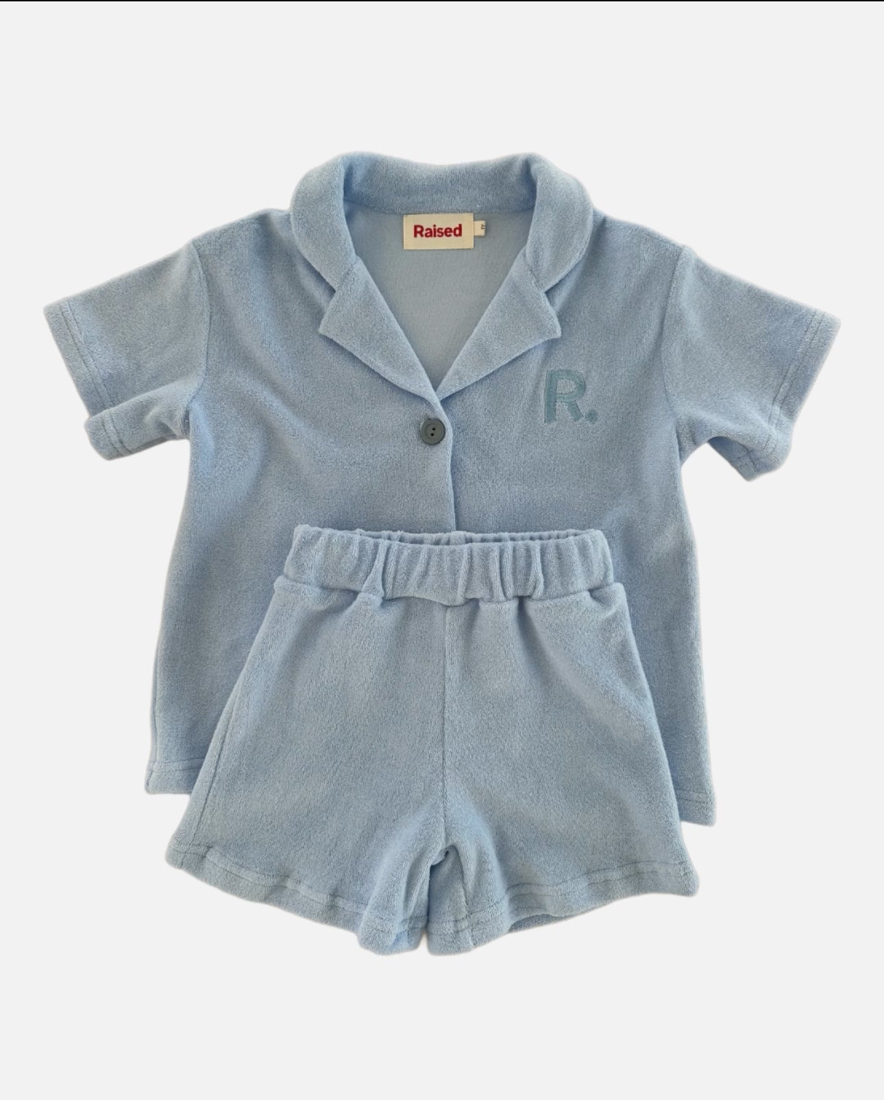 Flat lay of sky terry set, button up t-shirt and matching shorts